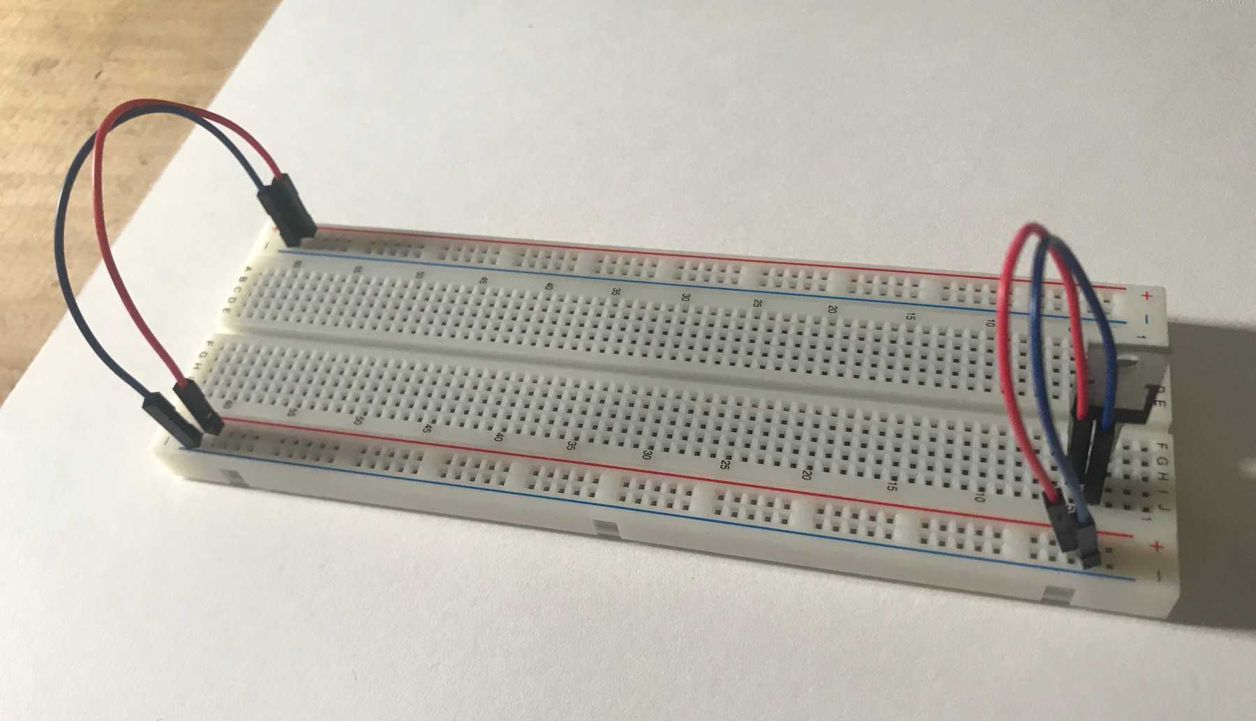 Initial breadboard setup featuring a 5V voltage regulator connected to the breadboard's positive voltage and ground